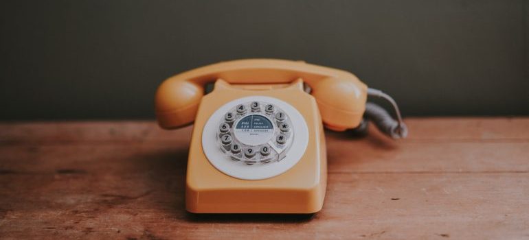 A yellow rotary dial phone to call movers Altadena