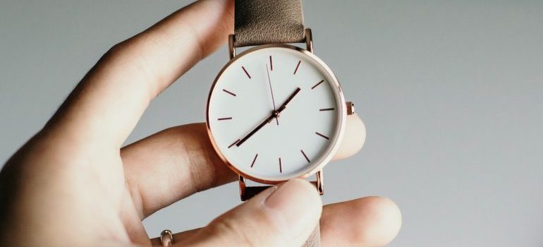 A person holding a watch - movers Altadena CA are here to speed up the moving process