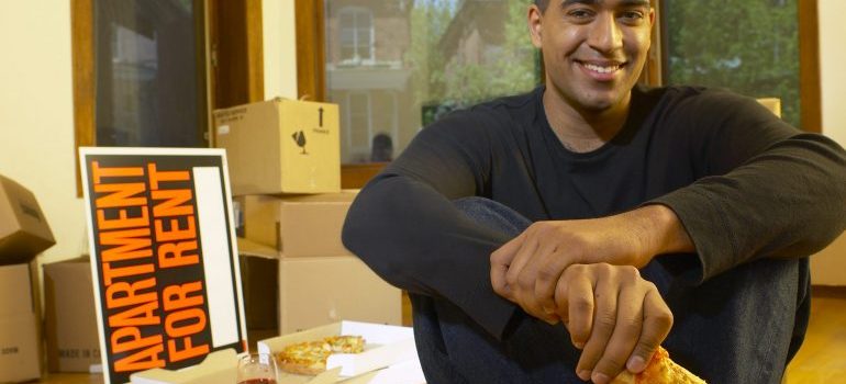 Man eating pizza in new apartment