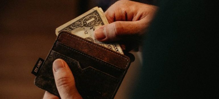 Man holding a wallet - hiring movers West Covina doesn't have to cost a fortune