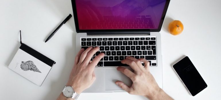 Person researching moving companies West Covina on the laptop