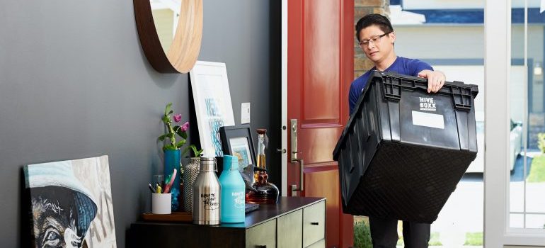 person carrying a plastic bin