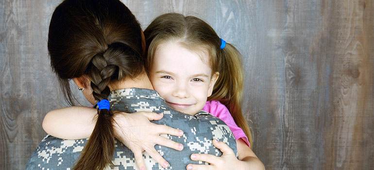 a girl hugging a soldier mom